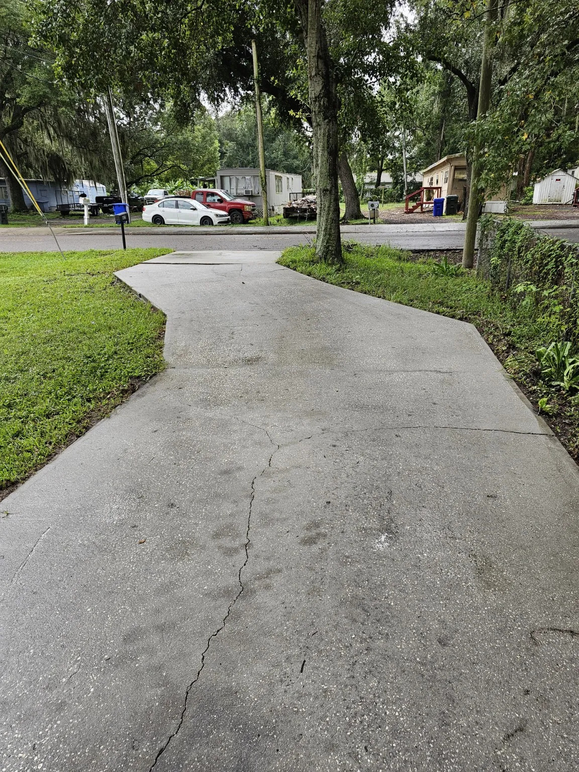 Lakeland curved concrete driveway after pressure washing, with surface buildup removed and existing cracks visible