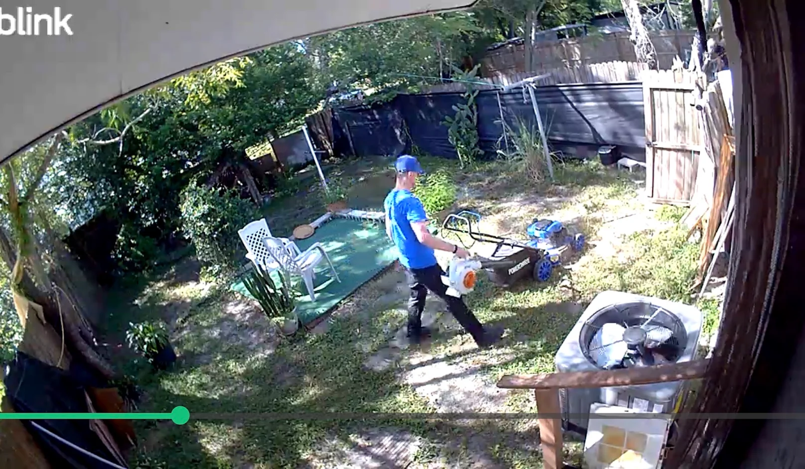 North Lakeland backyard after mowing, with overgrowth reduced and a worker beside the mower